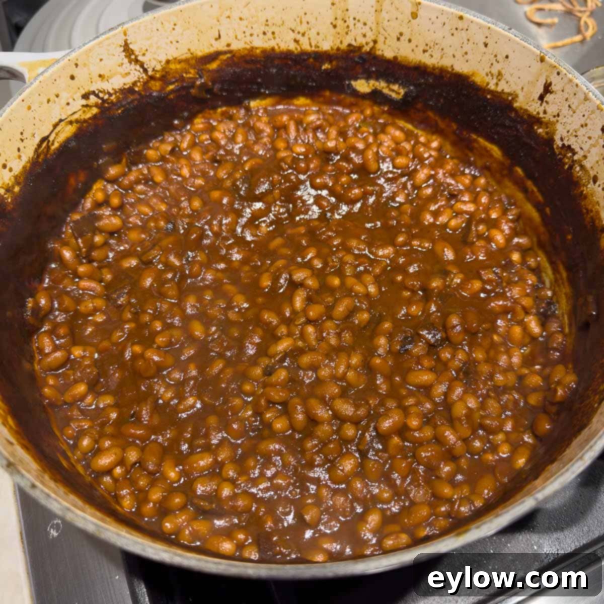 Finished Boston baked beans, now a deep, rich brown color, creamy, and saucy, indicating they are perfectly cooked.