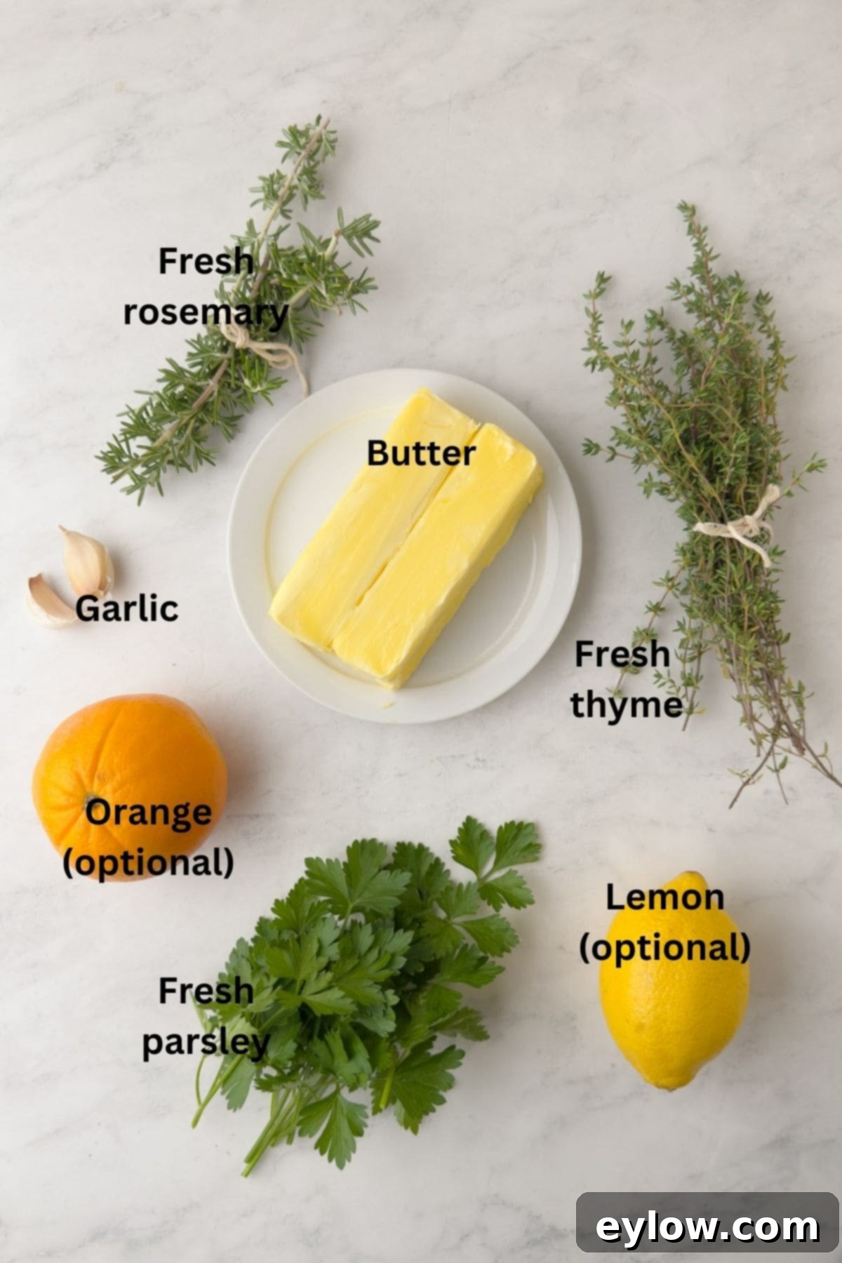 Ingredients for an herbed compound butter for turkey on a marble counter.