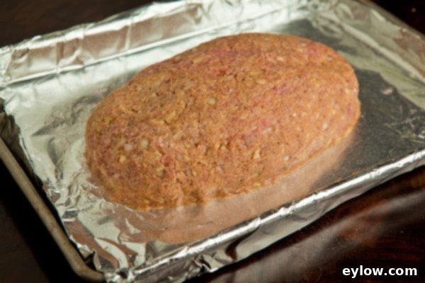 Meatloaf Process Mixing the meatloaf ingredients by hand in a large stainless steel bowl, showing the process | AFoodCentricLife.com