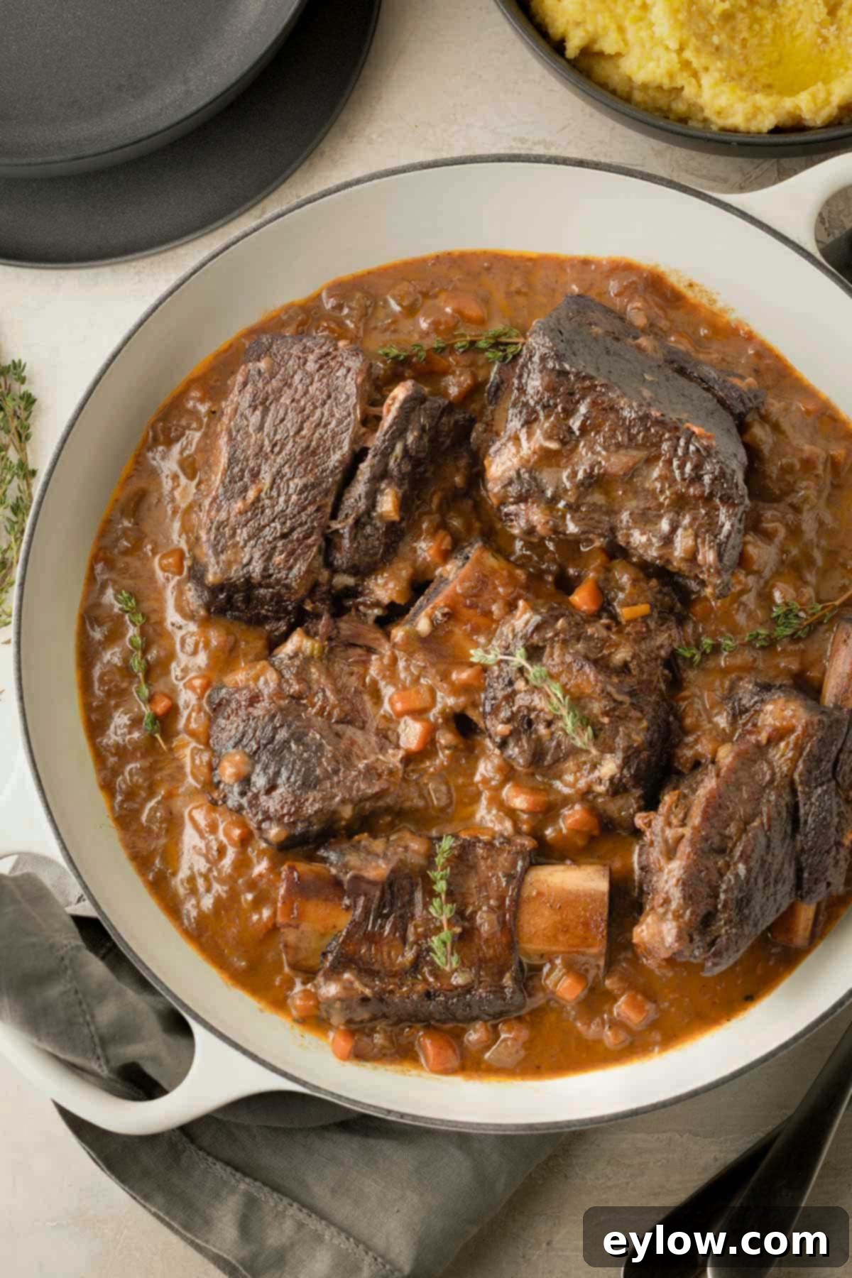 A white round casserole filled with red wine braised short ribs and rich creamy sauce.

