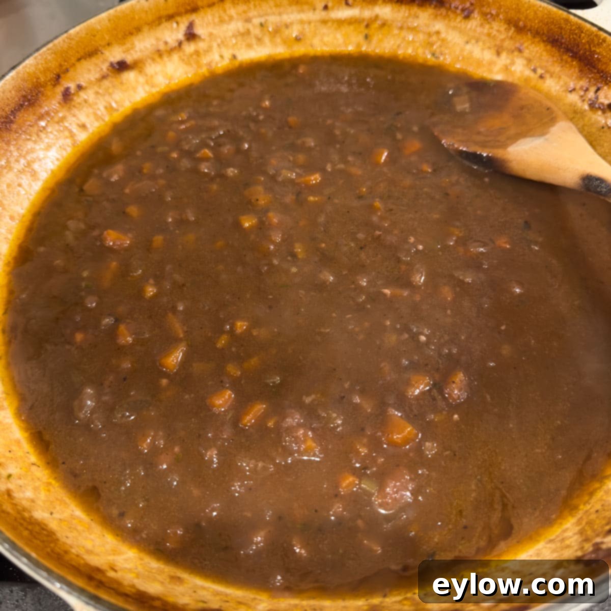 Finished thickened sauce for red wine braised beef ribs in a round pan.
