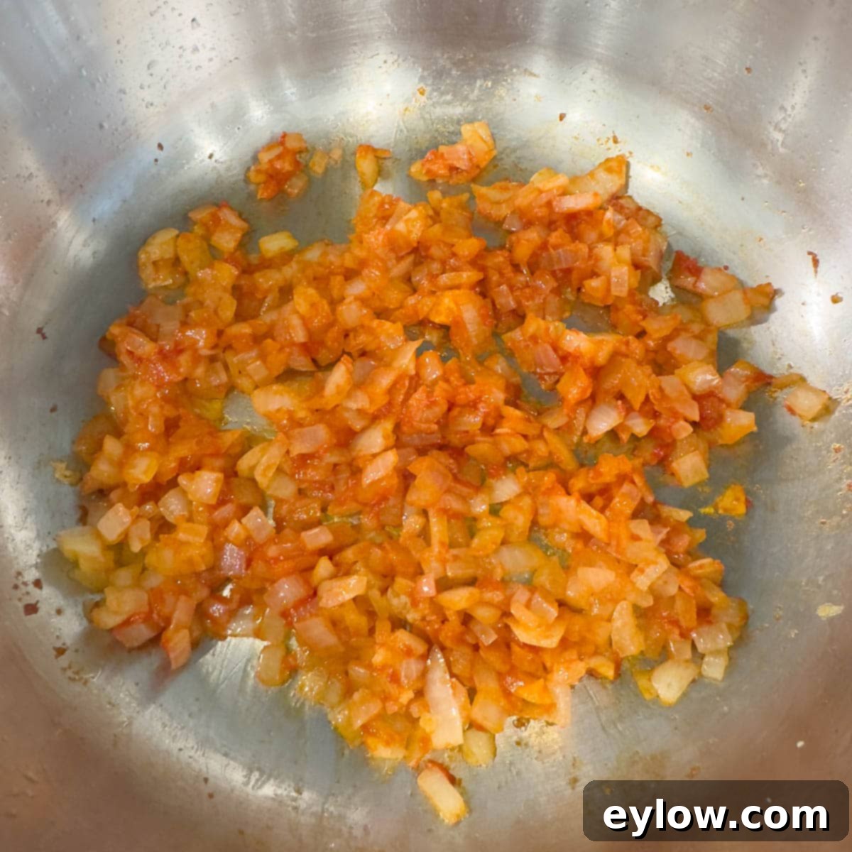 Cooking onions turned orange from adding tomato paste.