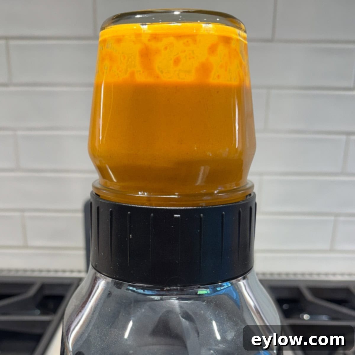 Bright red sauce in a small blender container. 