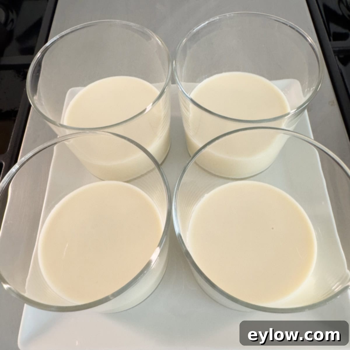 Velvety Strawberry Panna Cotta with Sweet Berry Drizzle 9 Four clear glasses with liquid panna cotta base ready for chilling.