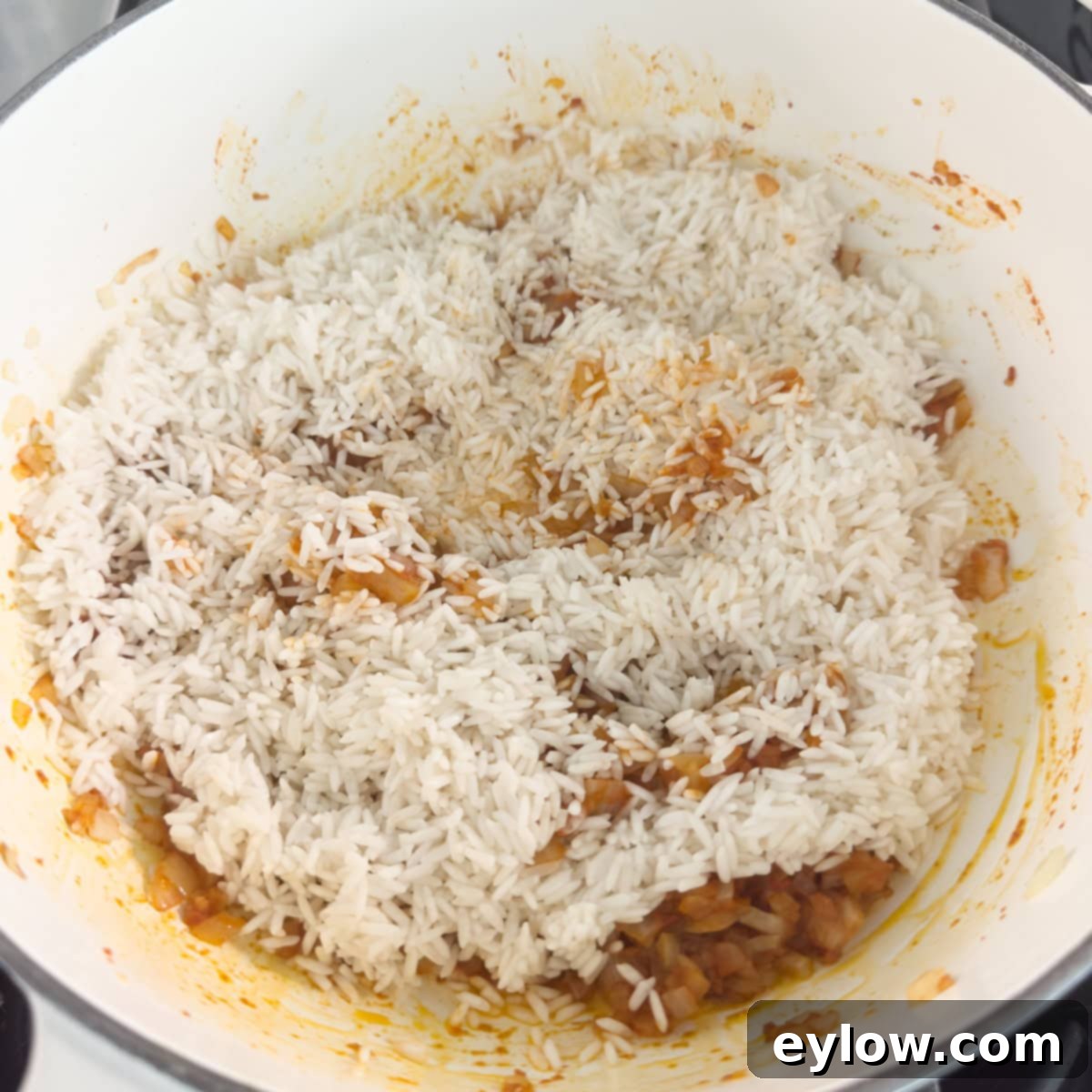 Vibrant Vegetable Rice Medley 6 White rice added to a pot of cooking onions and spices.