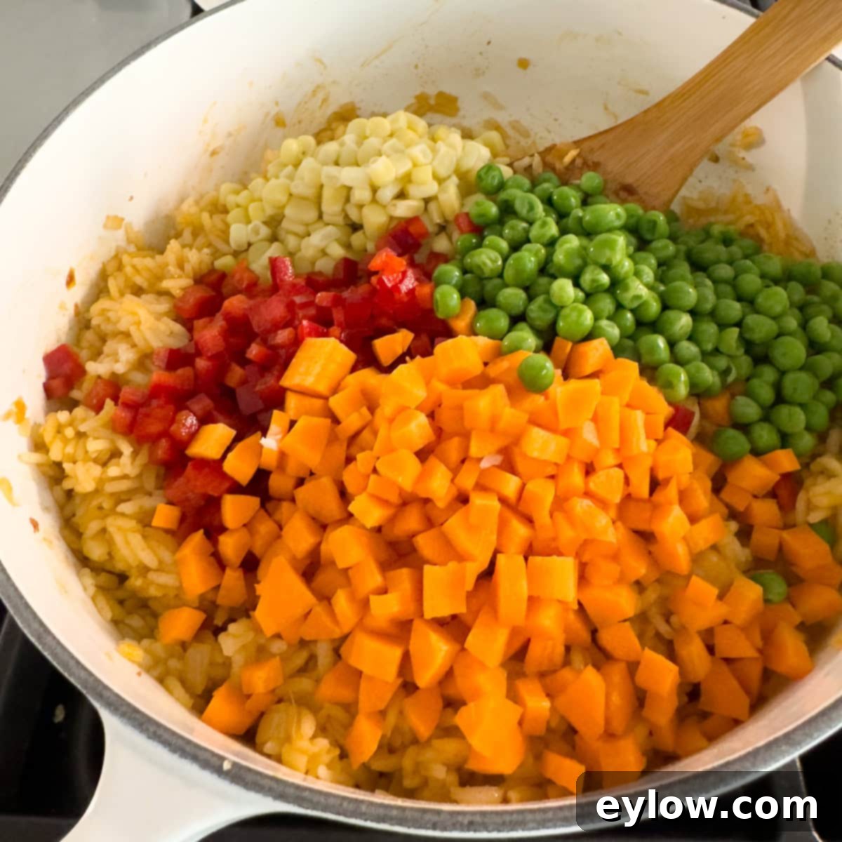 Vibrant Vegetable Rice Medley 9 Carrots, bell peppers, peas, and corn added to a pot of rice.