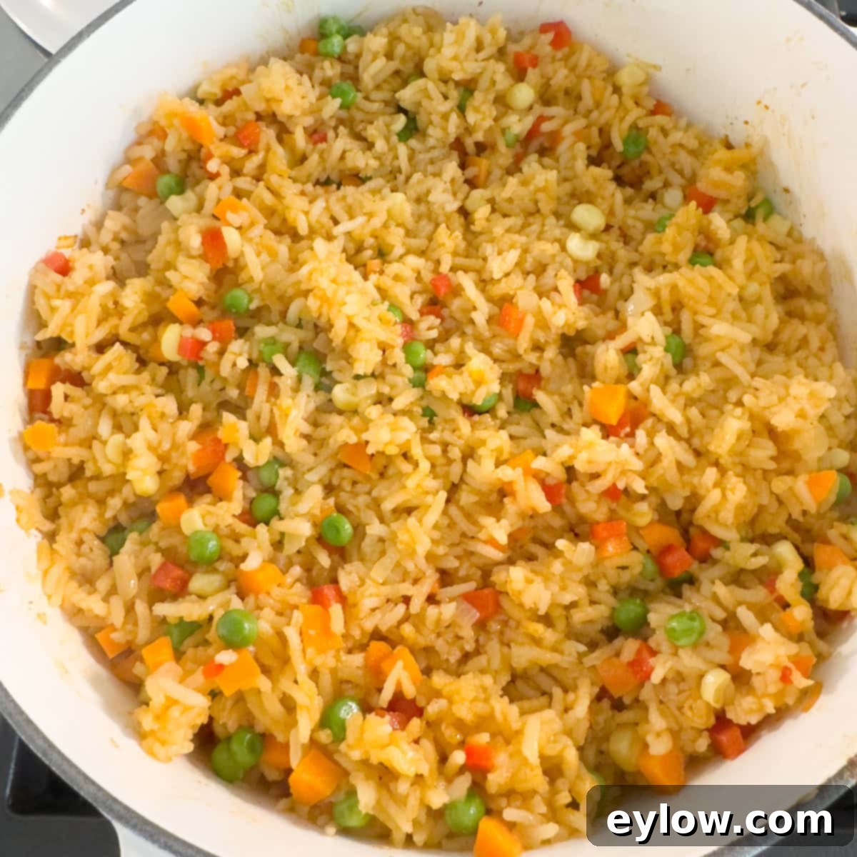 Vibrant Vegetable Rice Medley 10 Colorful rice with mixed vegetables in a white pot on the stove.