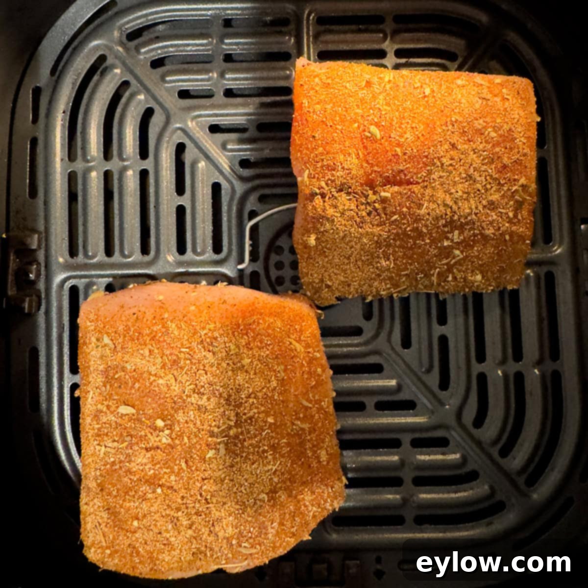 Crispy Blackened Mahi Mahi in the Air Fryer 6 Two fish filets coated with blackening seasoning in an air fryer basket.