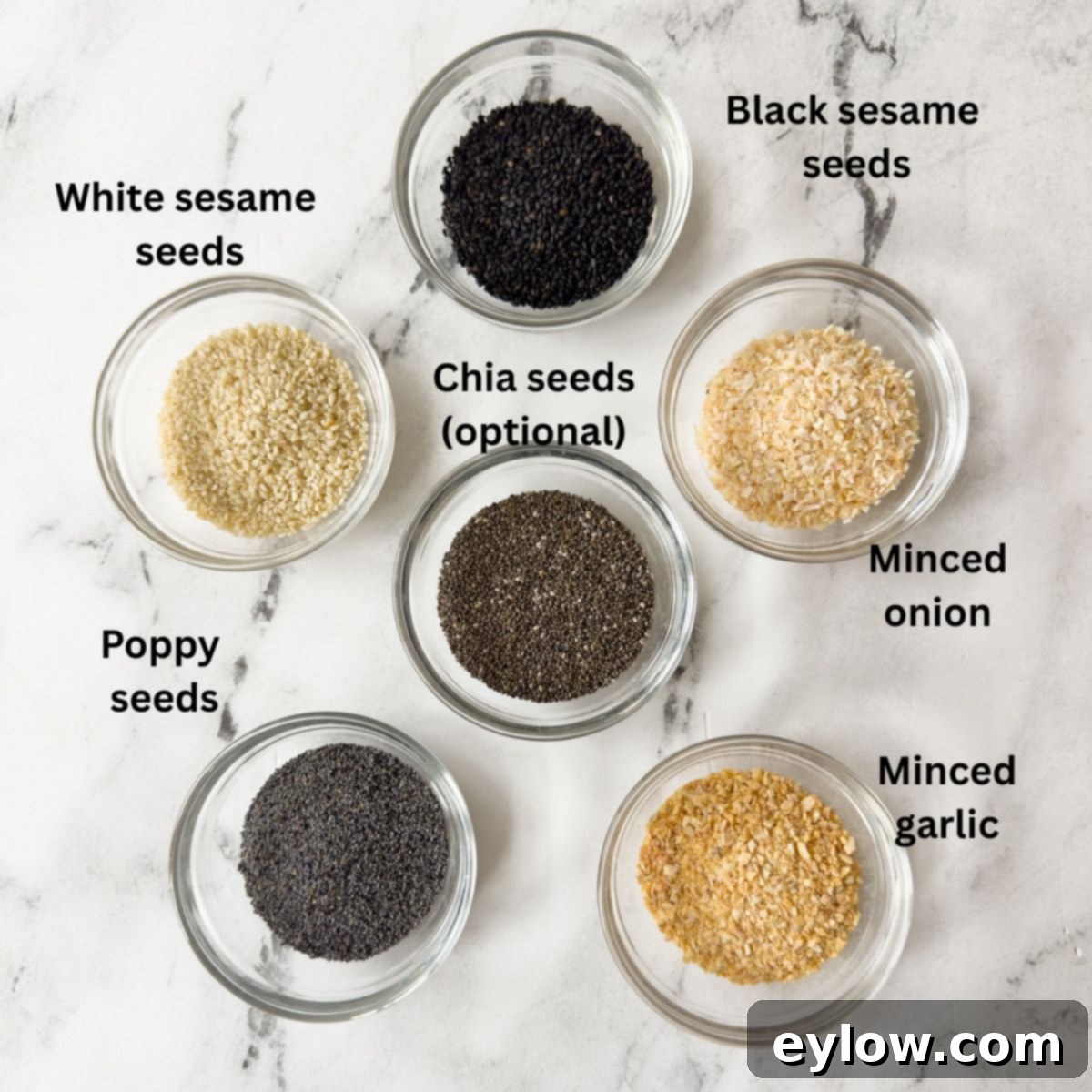 DIY Everything Bagel Seasoning 3 Small glass prep bowls with seeds, minced garlic and onion to make everything bagel seasoning.