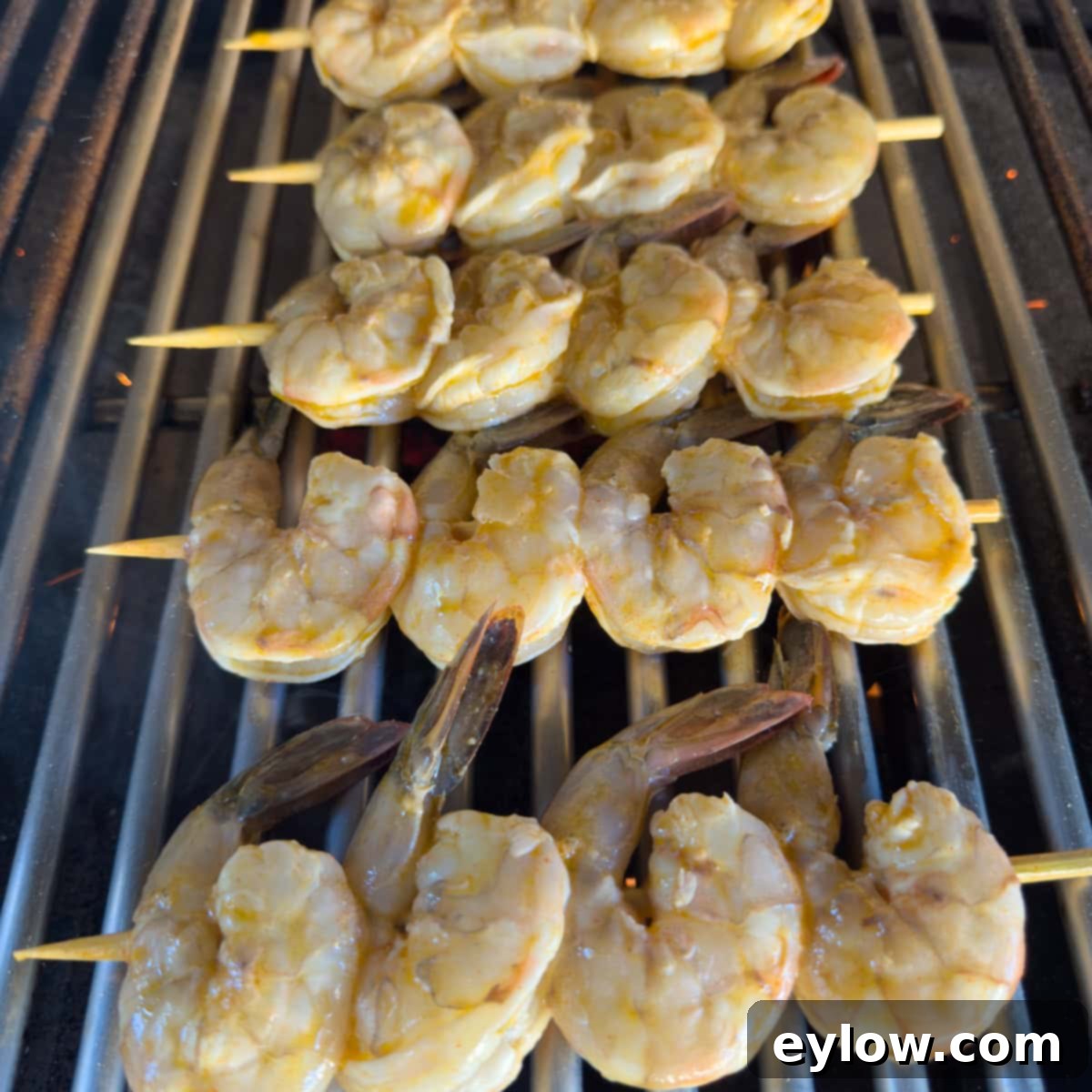 Shrimp skewers on hot grill grates starting to cook.