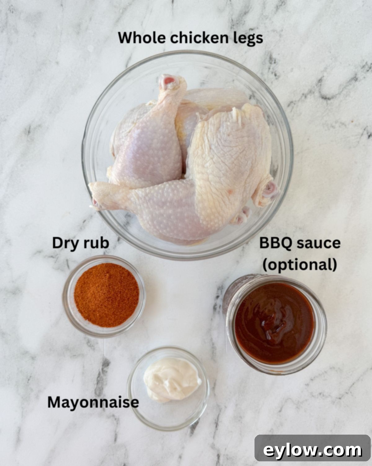 Ingredients for smoked chicken legs with chicken, dry rub, mayo, and sauce.