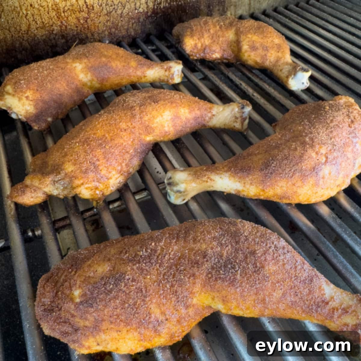 Golden brown smoked whole chicken legs ready to pull from the grill.