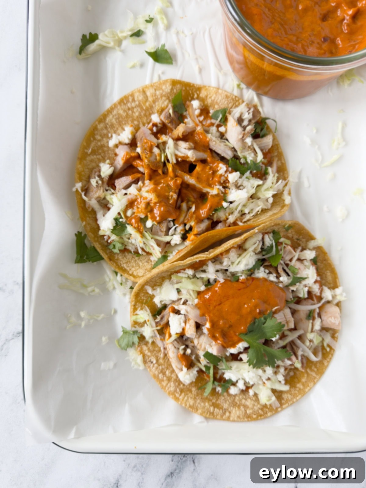 Harissa aioli dolloped on chicken tacos with corn tortillas.
