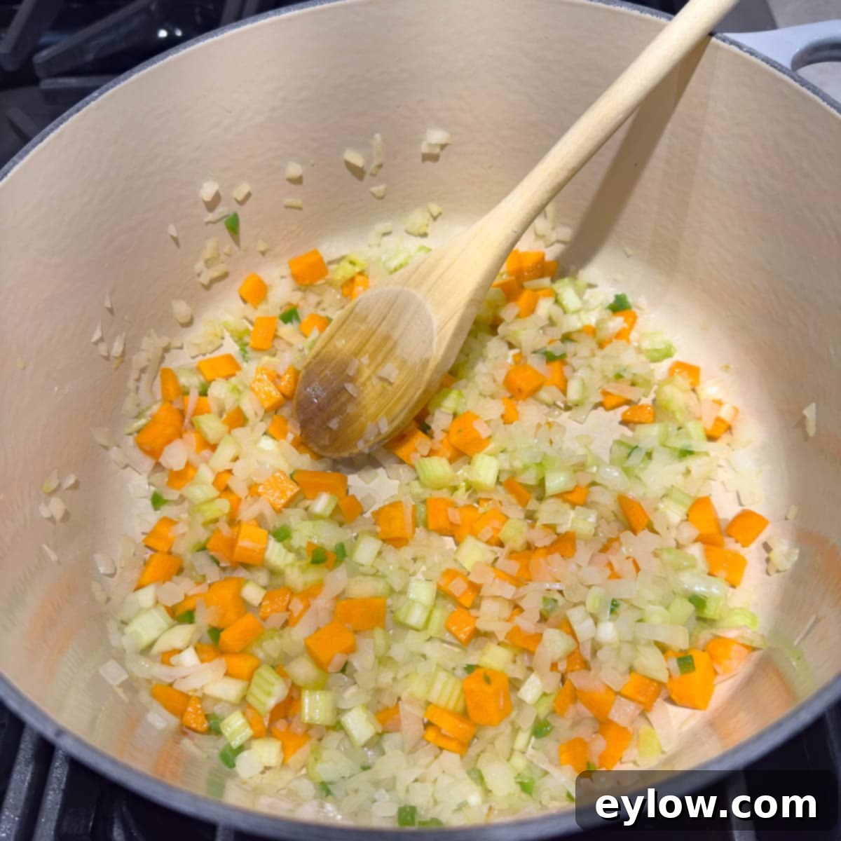 Vegetables for chicken soup sautéing in a Dutch oven.