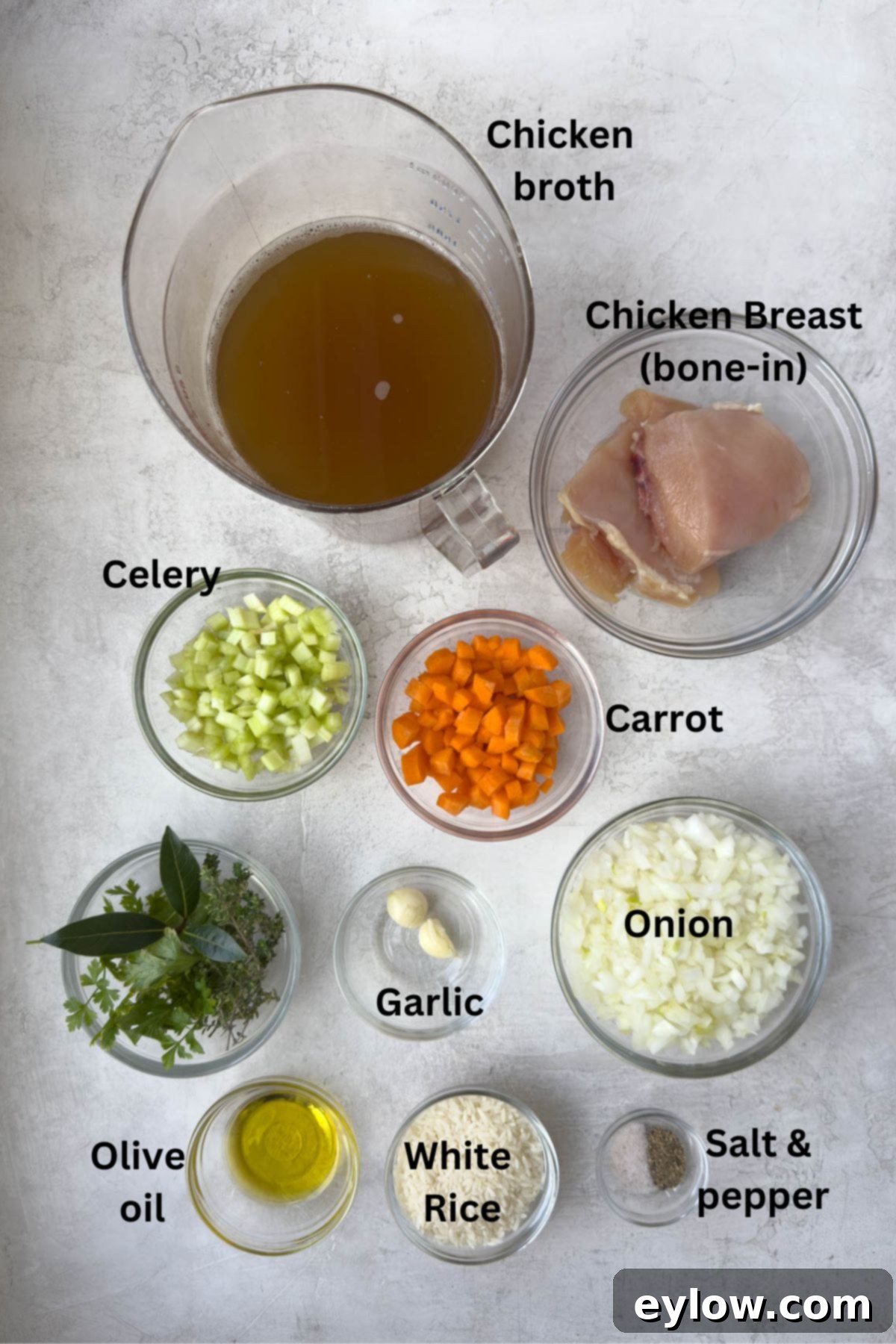 Ingredients for chicken rice soup prepped in bowls.