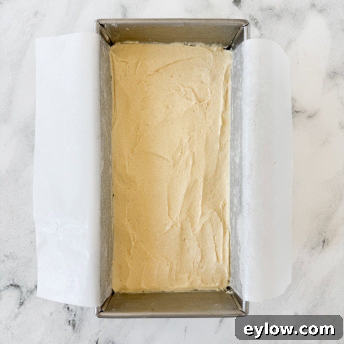 Artisan Gluten-Free Cream Cheese Pound Cake 12 Pale yellow pound cake batter smoothed into a loaf pan with parchment.