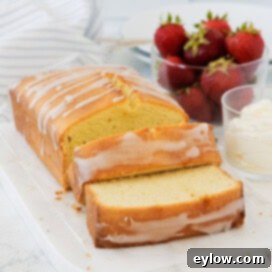 Artisan Gluten-Free Cream Cheese Pound Cake 15 Sliced of golden pound cake with strawberries and a small bowl of whipped cream.