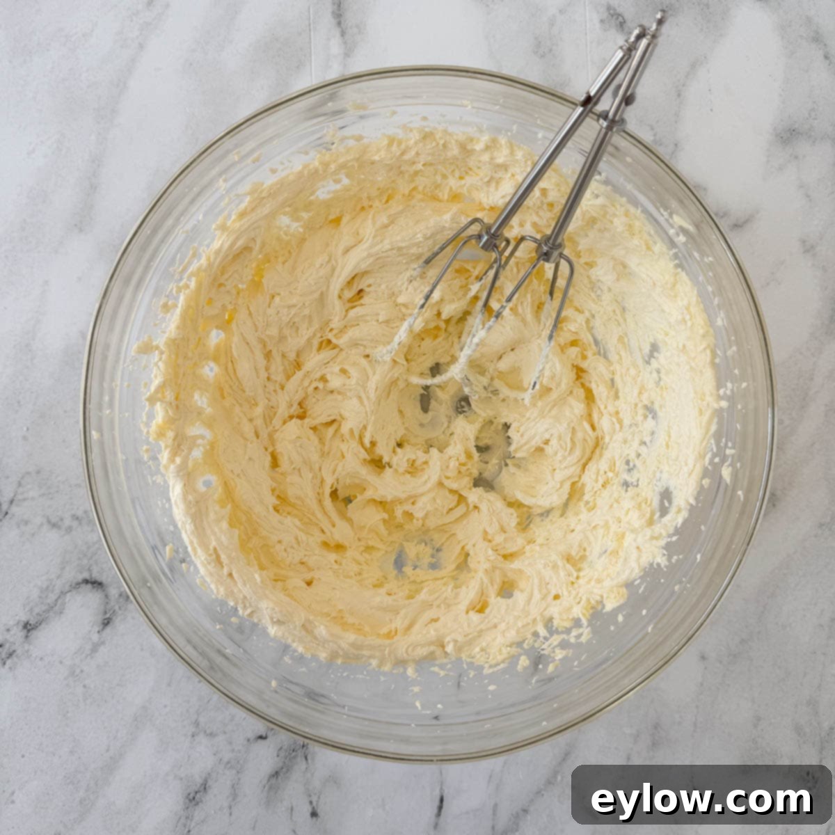 Artisan Gluten-Free Cream Cheese Pound Cake 9 Pale yellow creamed butter and sugar in a bowl with beaters.