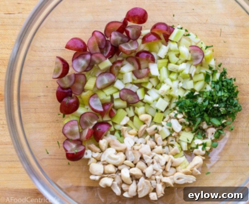 Fresh ingredients like grapes, cashews, celery, and cilantro, all prepped for mixing into the chicken salad.