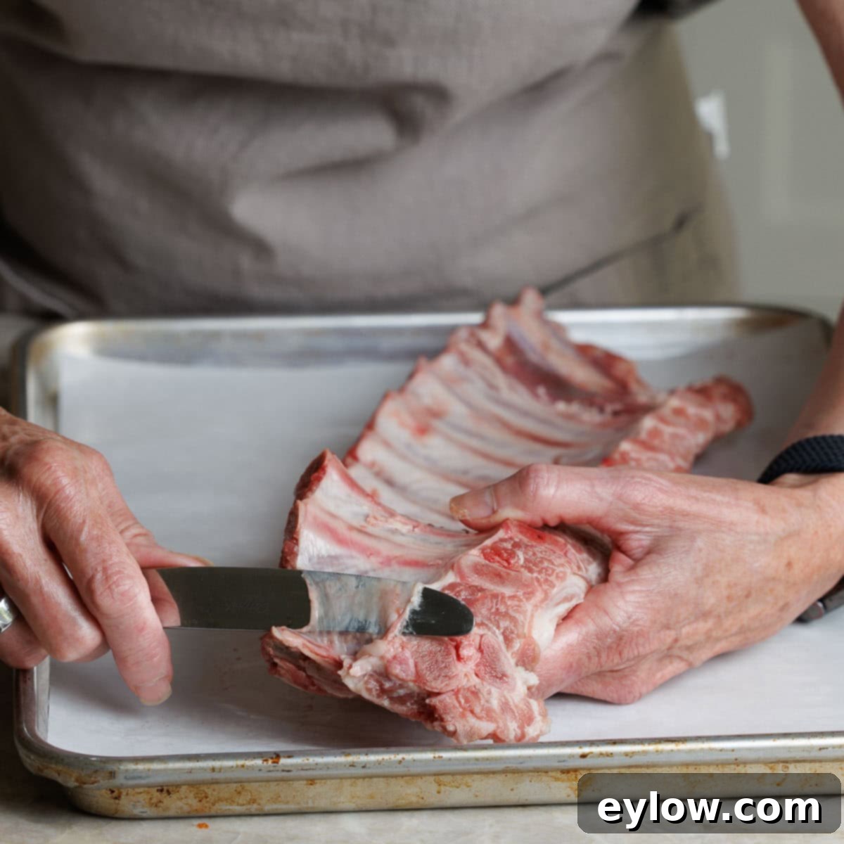 A table knife slipped under the silver skin on the under side of a rack of ribs.