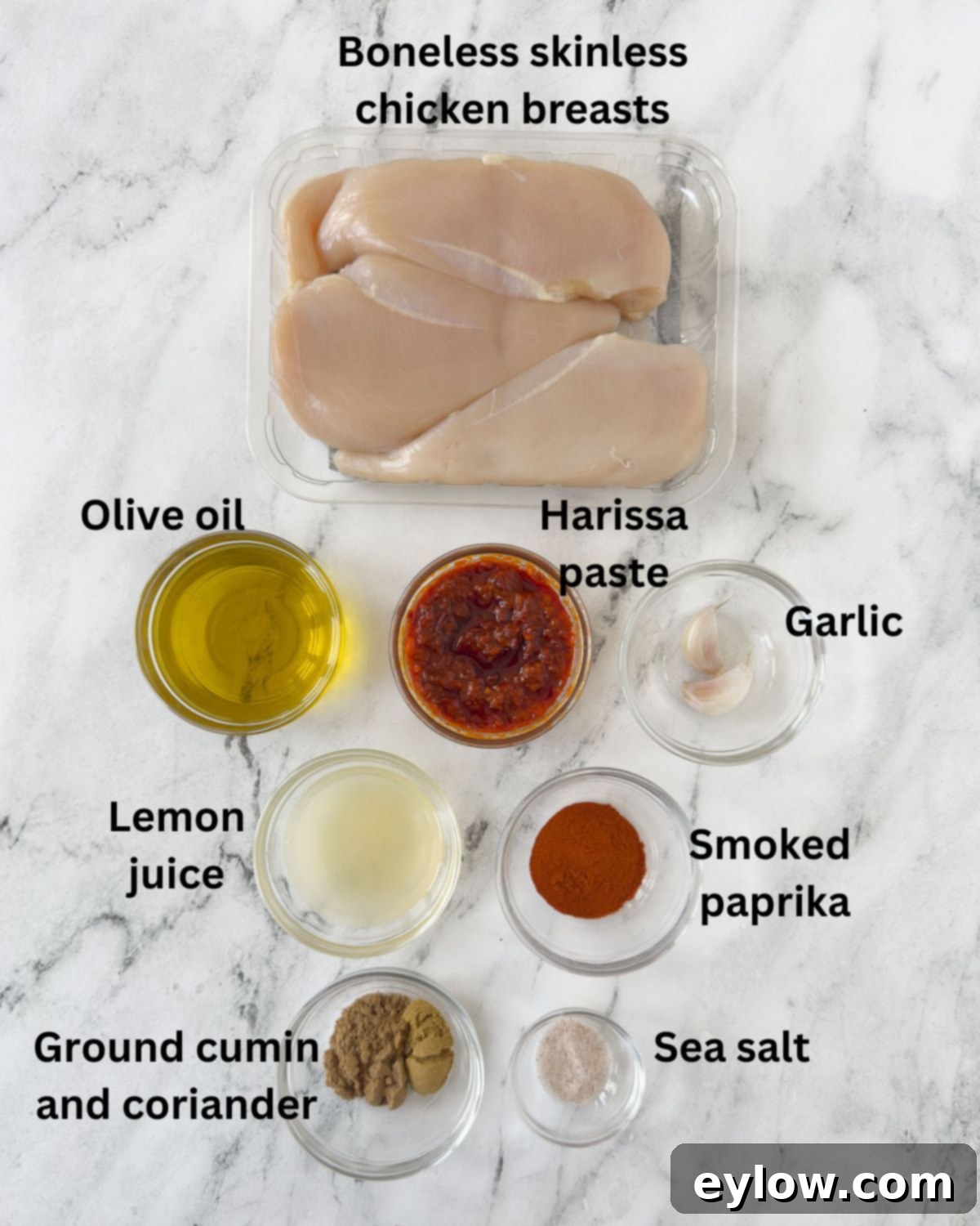 Fiery Harissa Chicken Skewers 3 Individual bowls containing fresh ingredients for harissa chicken: chicken pieces, olive oil, harissa paste, lemon, garlic, and various spices.