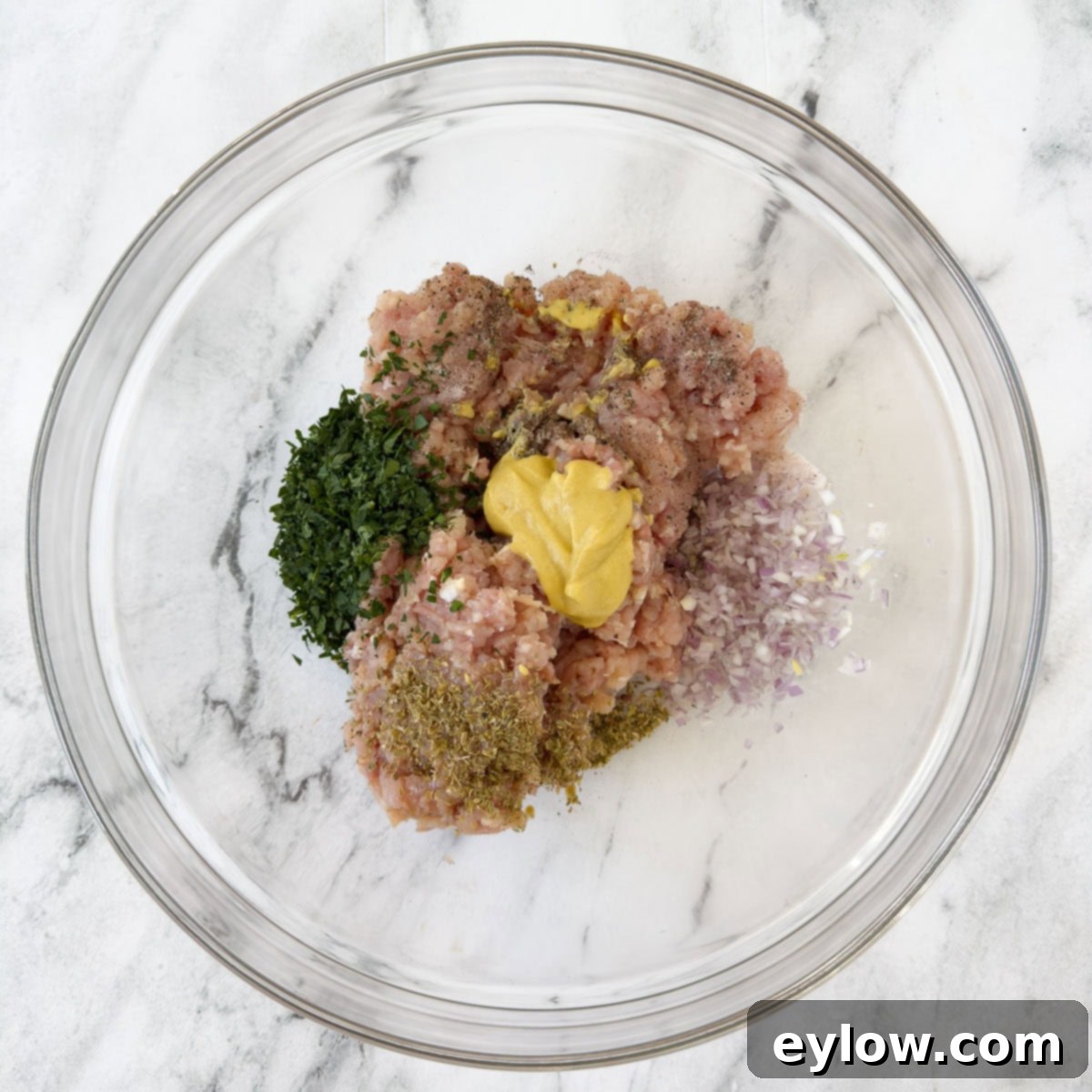 Homemade Air Fryer Chicken Patties 4 Ingredients for chicken burgers in a glass bowl to be mixed.