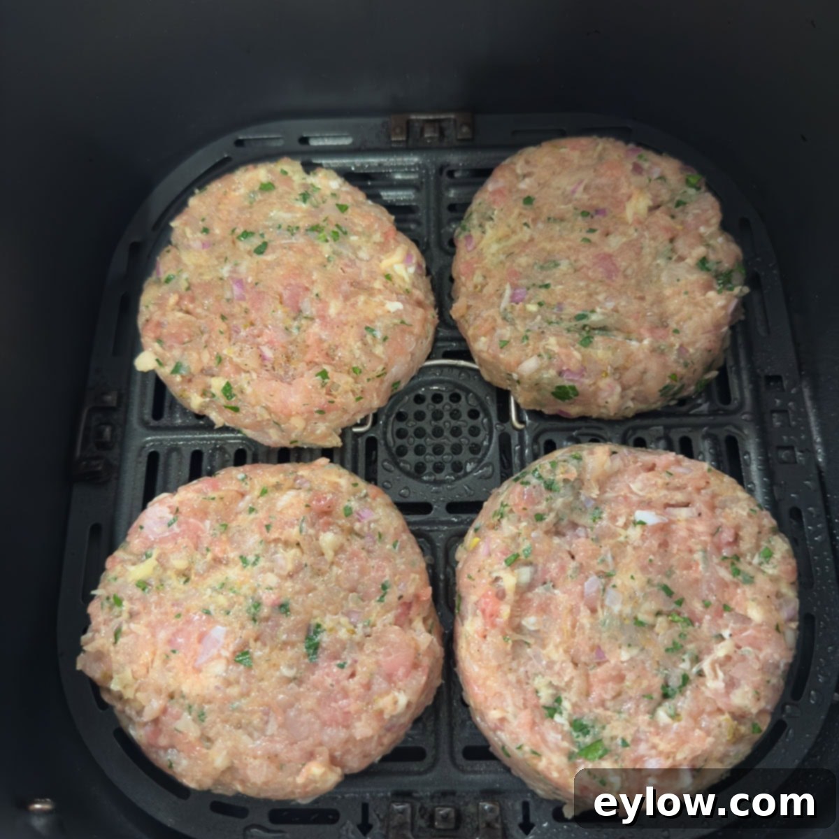 Homemade Air Fryer Chicken Patties 6 Chicken patties in an air fryer for cooking.