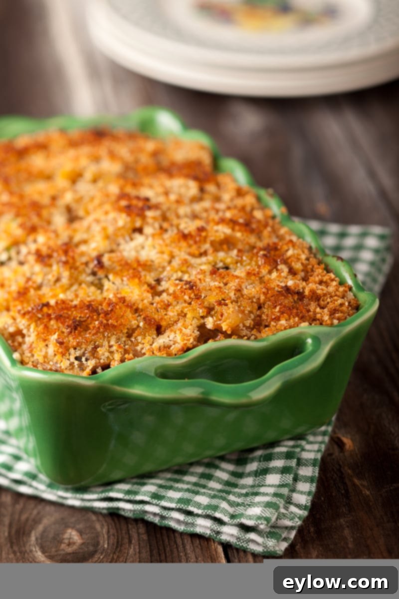 Delicious healthy turkey tetrazzini casserole in a green ceramic baking dish, ready to be served on a rustic wooden table.