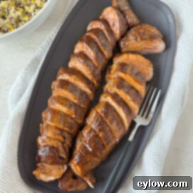 Pellet Grill Smoked Pork Tenderloin 9 BBQ glazed smoked pork tenderloin sliced on a gray platter for serving.