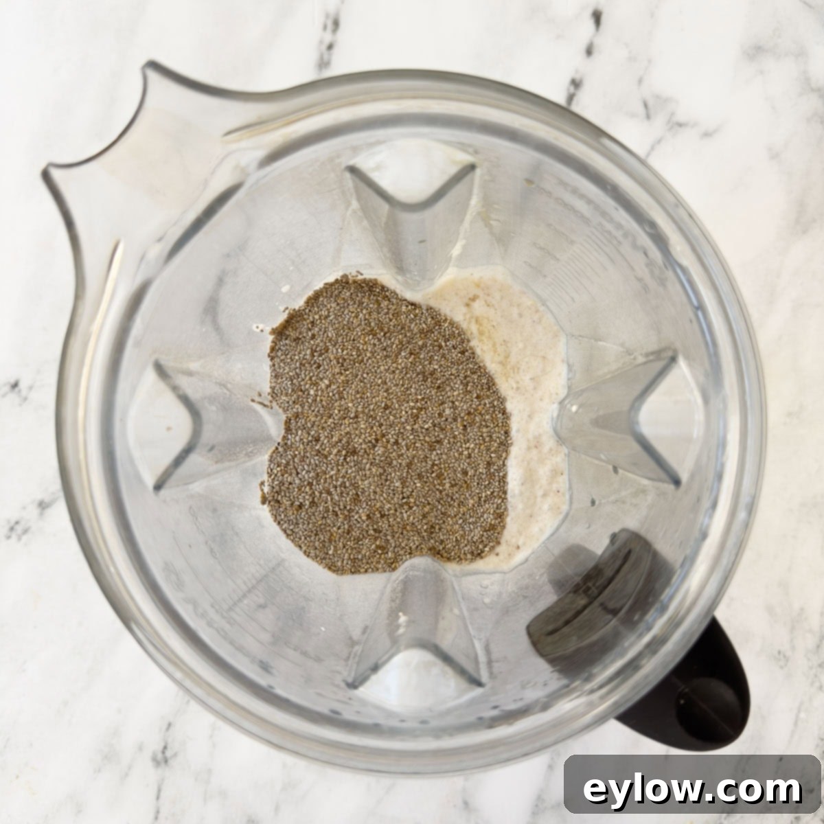 Blending milks and chia seeds for chia pudding with coconut milk in a blender container.