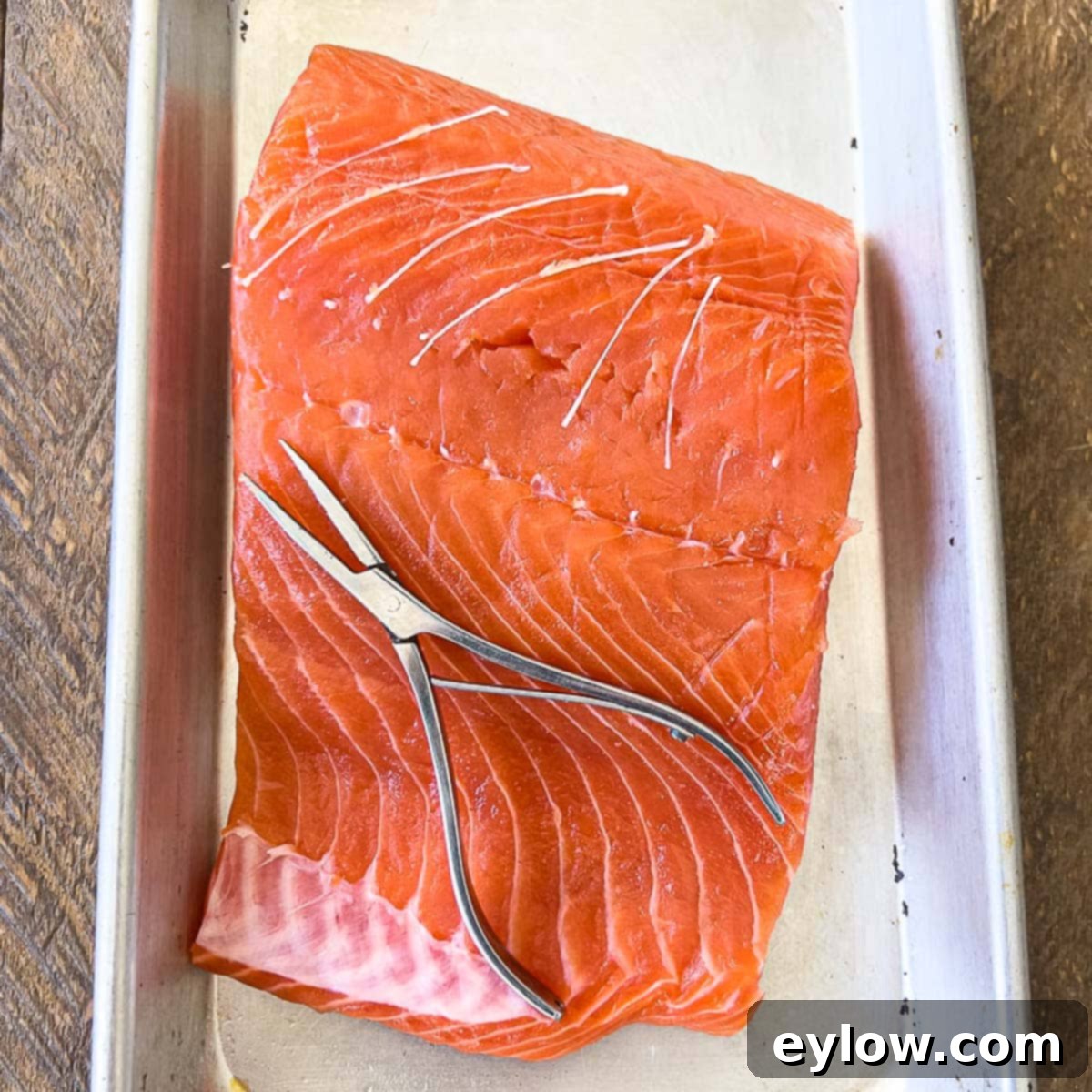 Seamless Salmon Skinning 5 Removing pin bones from raw salmon with pliers.