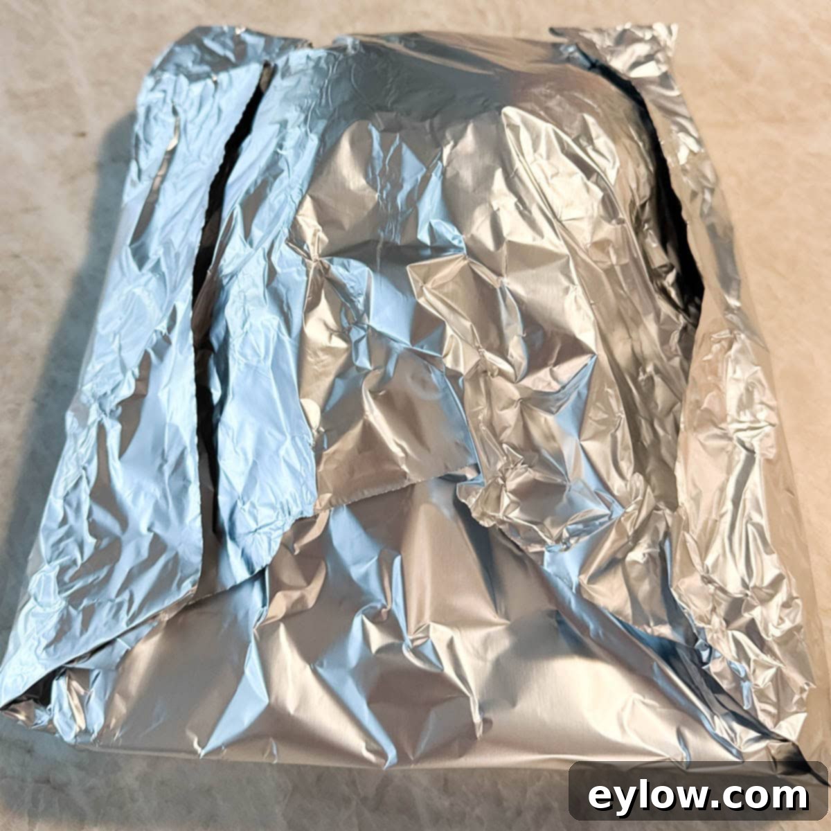 A foil covered turkey breast resting before carving. 