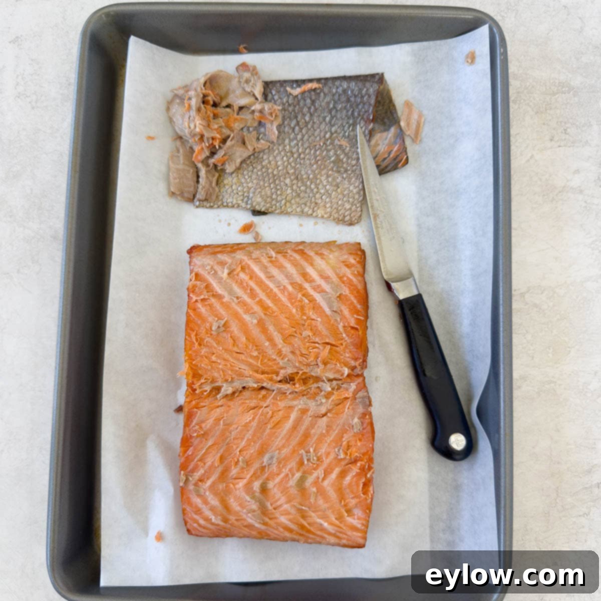 Pellet Grill Smoked Salmon Perfection 12 The bottom of a smoked salmon fillet being skinned and trimmed.