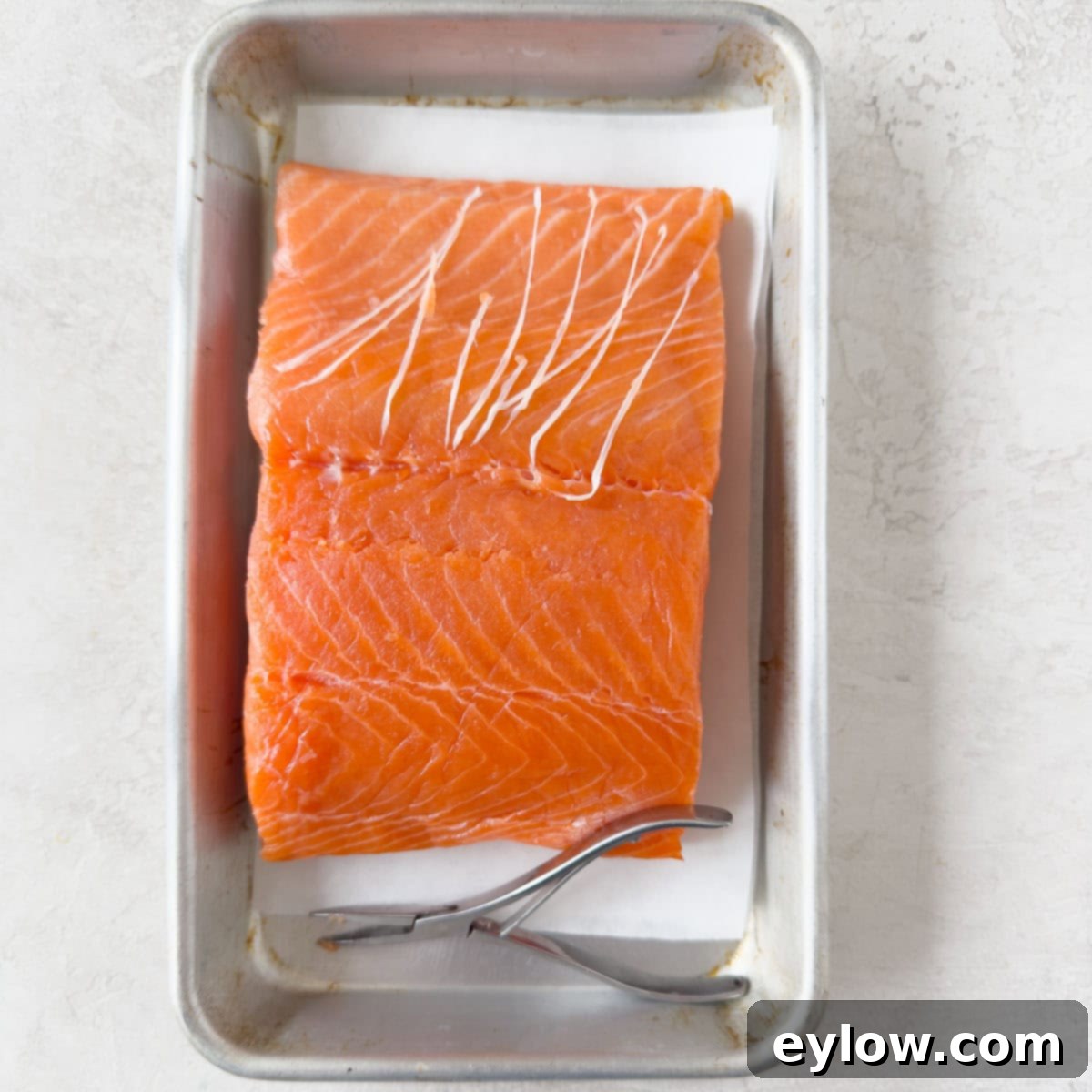 Pellet Grill Smoked Salmon Perfection 4 Bright orange salmon filet showing pin bones removed on a metal tray.