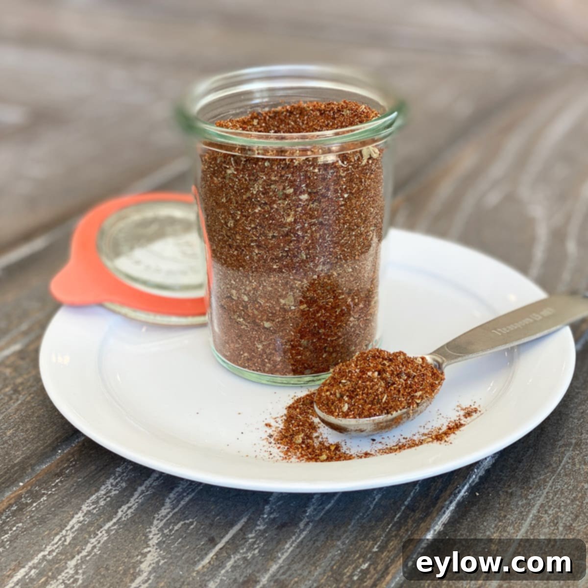 Homemade taco seasoning blend in a glass jar, showing a mix of vibrant spices.
