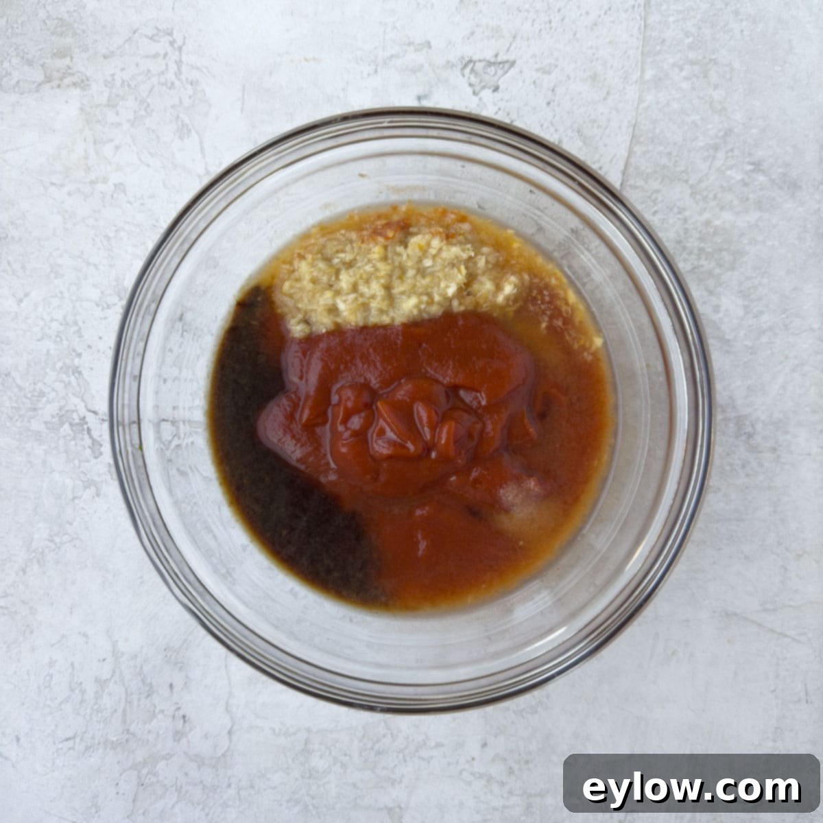 All seafood sauce ingredients in a clear glass bowl, ready for mixing.