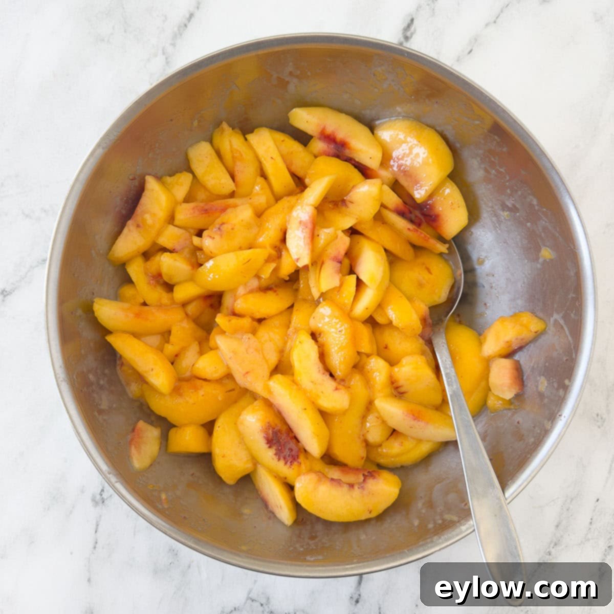Golden sliced yellow peaches in a large mixing bowl.