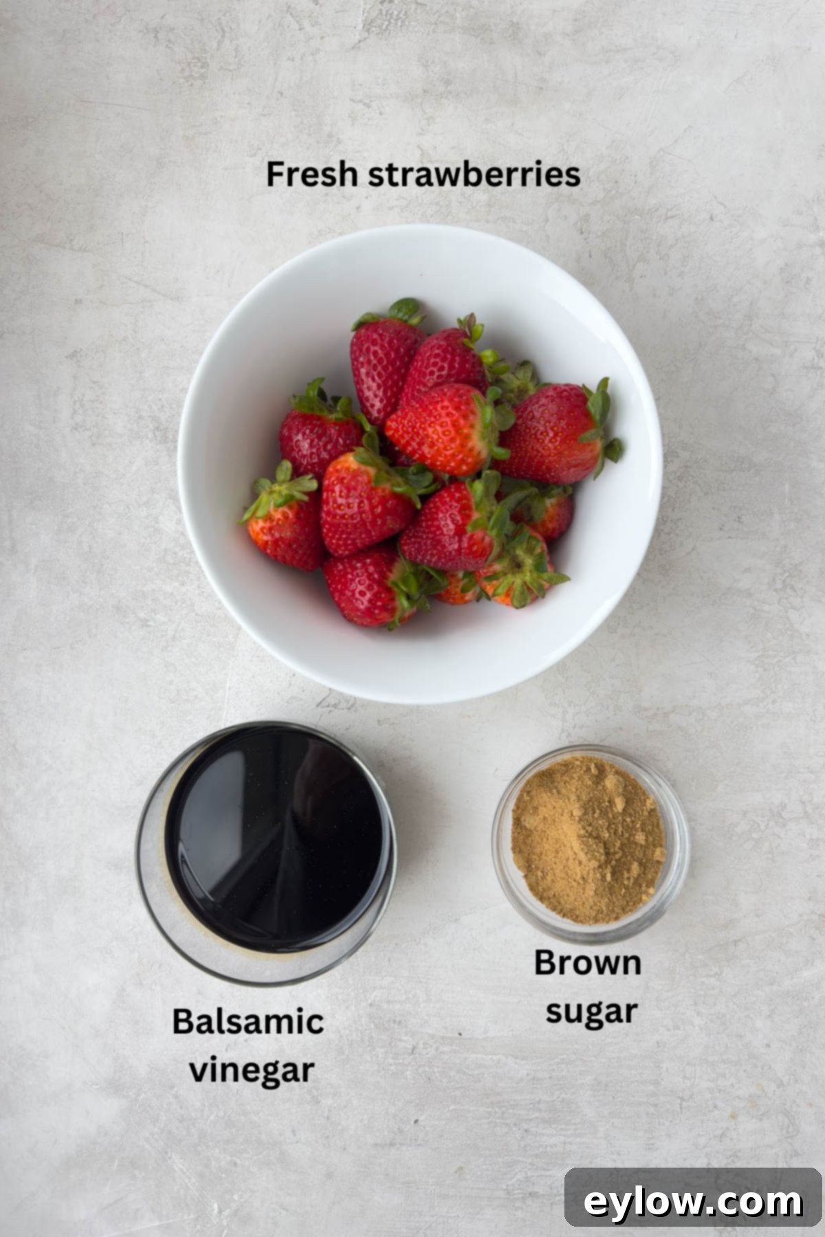 Homemade Balsamic Glazed Strawberries 3 A bowl of riper ed strawberries, a glass bowl of balsamic vinegar, and a little brown sugar.