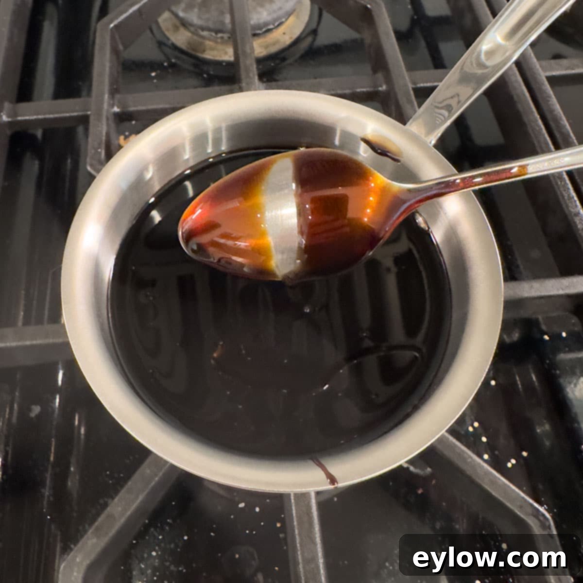 Homemade Balsamic Glazed Strawberries 5 Finished balsamic glaze on the back of a spoon like syrup.