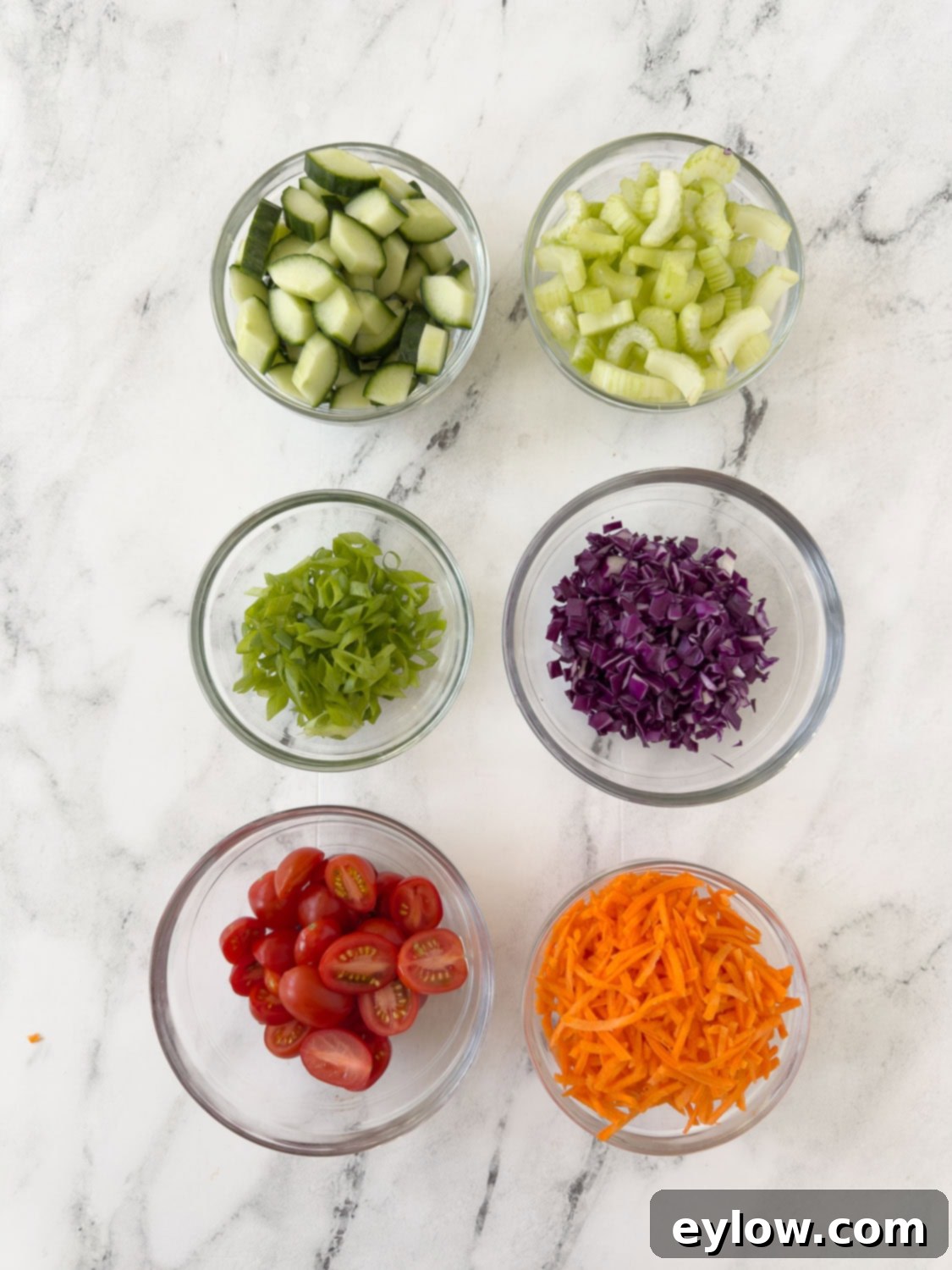 Prepped ingredients for a buffalo chicken salad in small bowls.