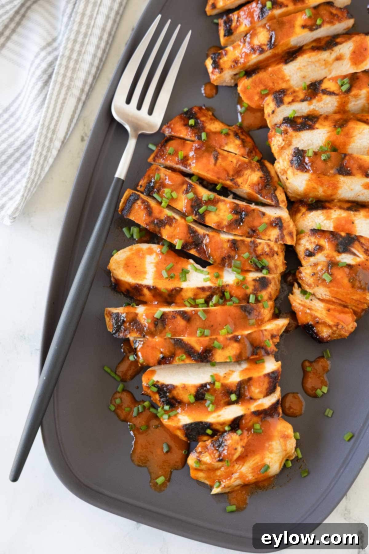 Zesty Grilled Buffalo Chicken 2 Bright orange Grilled Buffalo Chicken with perfect grill marks on a gray platter.