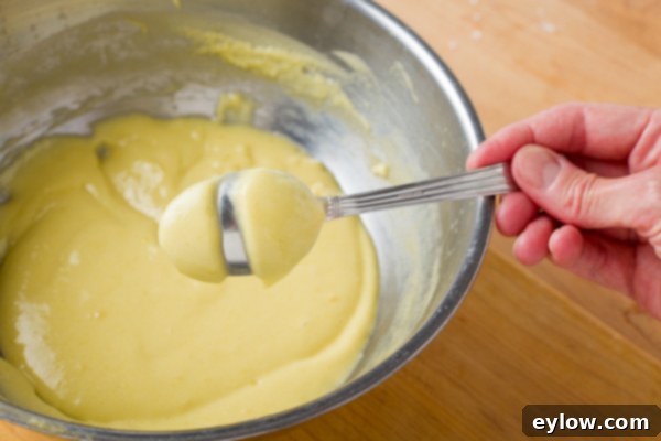 Lemon Mousse -5381 The back of a stainless steel spoon with a line through it, demonstrating that the lemon curd has reached the correct consistency and is ready.