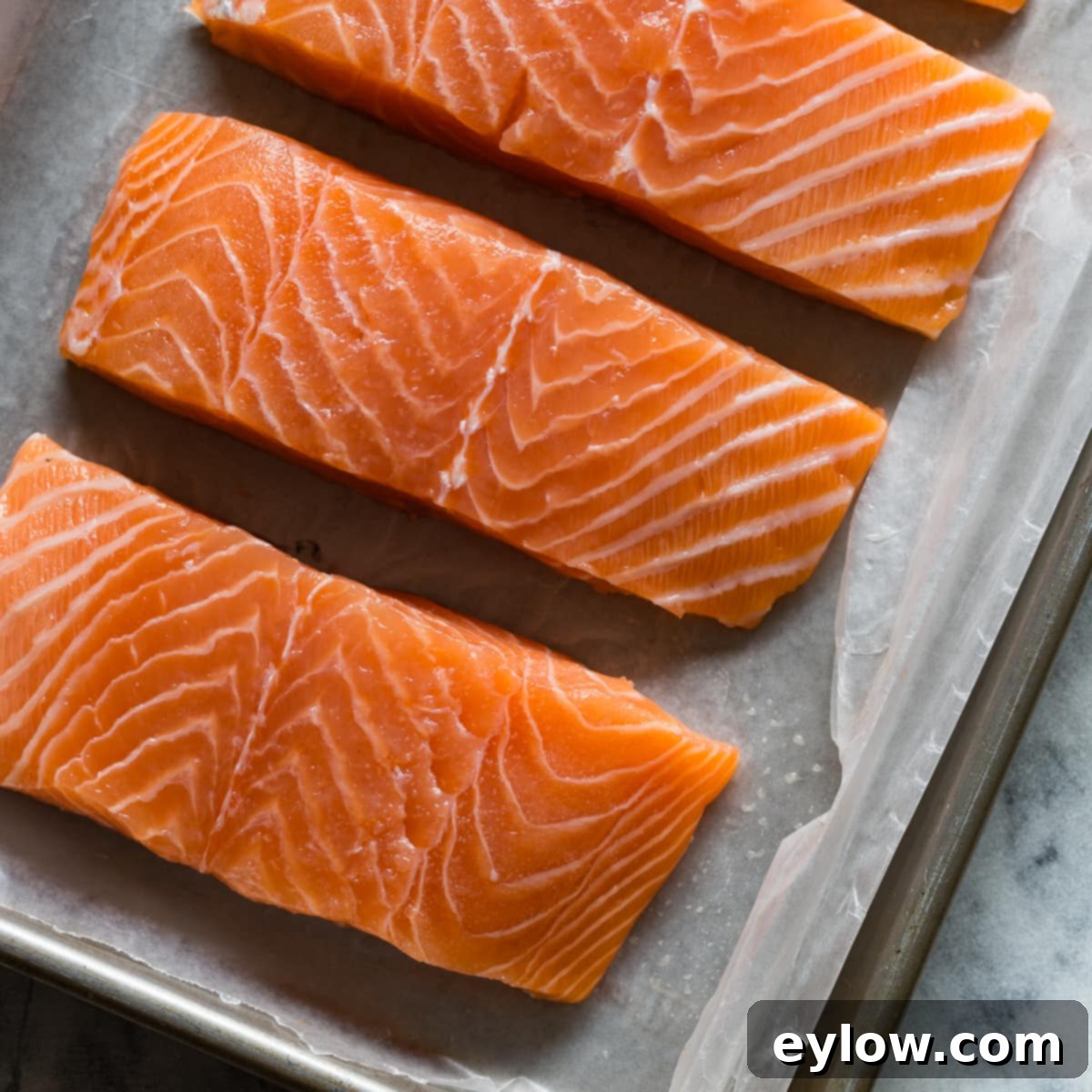 Effortless Skillet Salmon 3 A tray of perfectly cut bright orange salmon filets ready to cook.