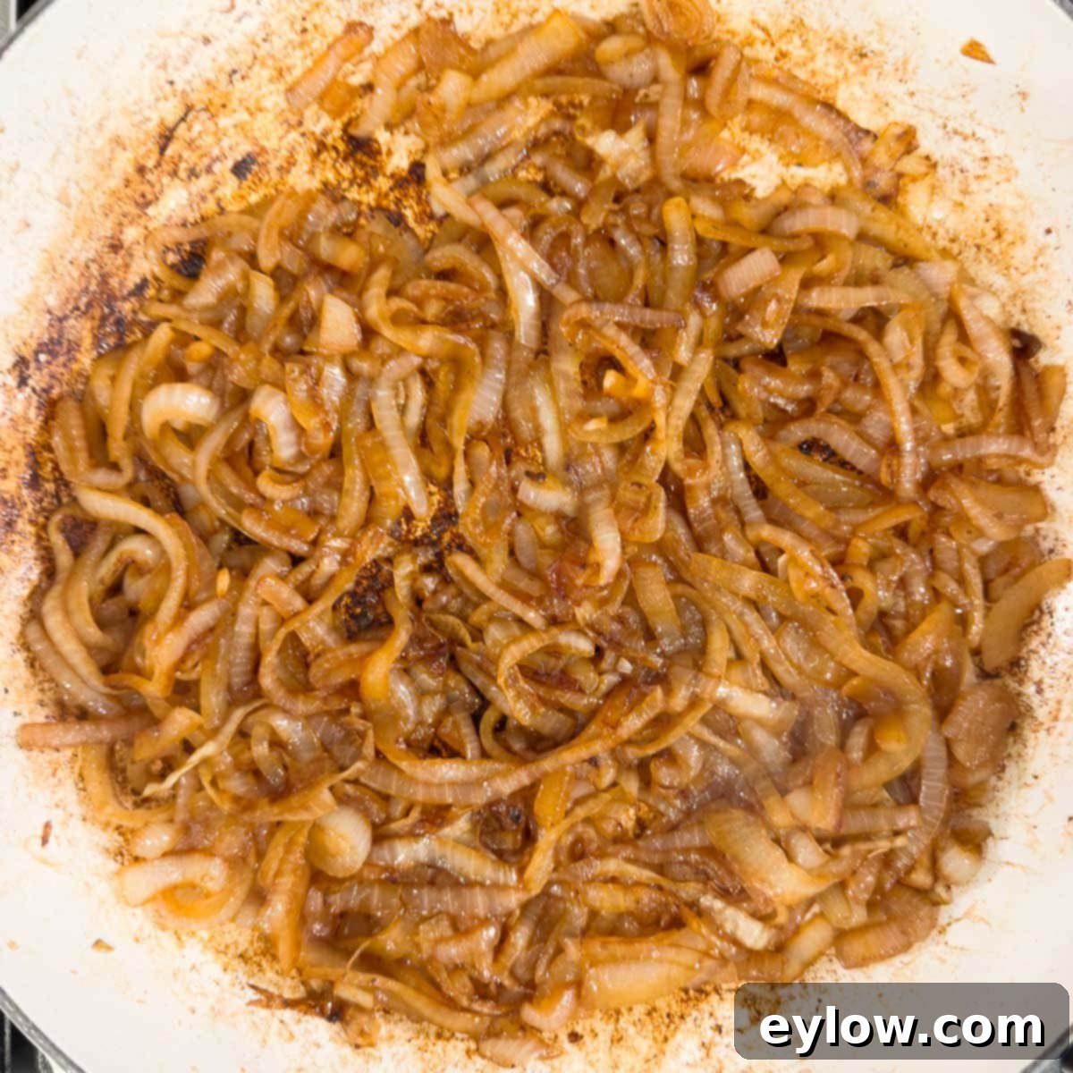 Deep golden brown caramelized onions, fully cooked, in a pan, ready for garlic and Worcestershire sauce.