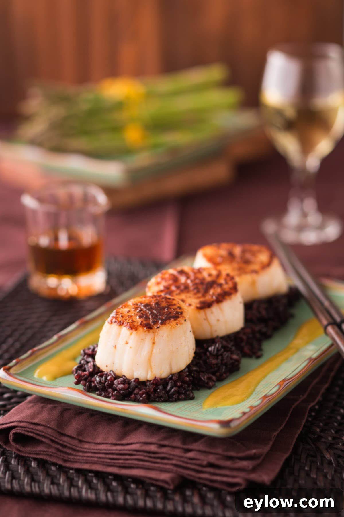 Seared Scallops with Orange Miso Sauce, served over rice with chives.