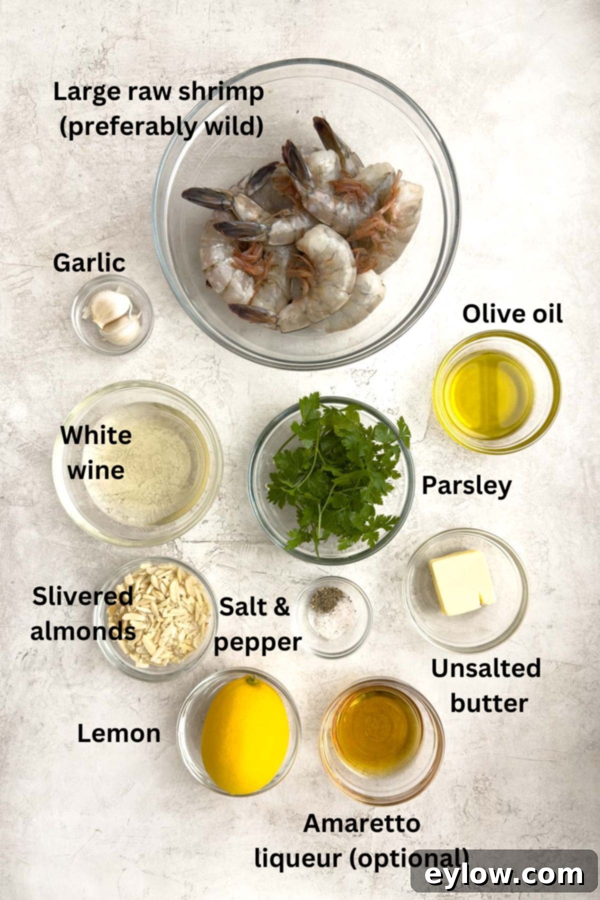 Effortless Oven-Baked Shrimp Scampi 3 Fresh ingredients for shrimp scampi laid out in small bowls for preparation.