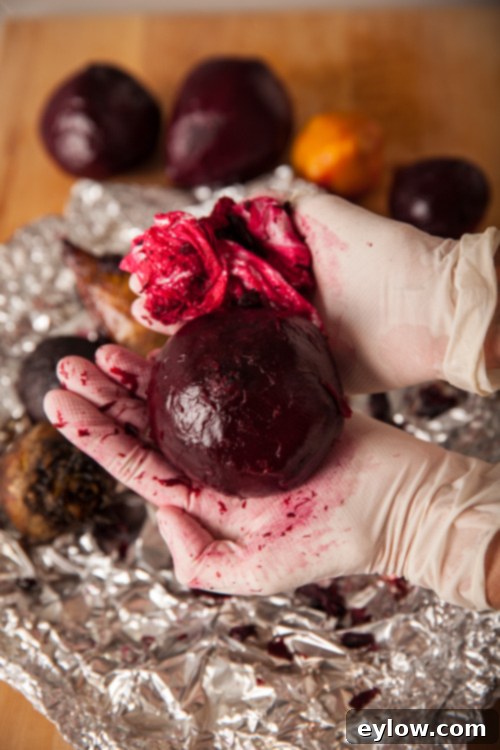 Vibrant Roasted Vegetable and Kale Bowl 3 Removing skin from a roasted beet.