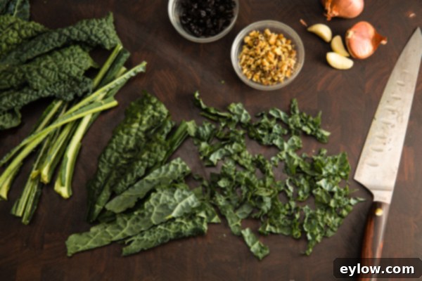 Vibrant Roasted Vegetable and Kale Bowl 5 Kale ribbons on a cutting board, prepared for a salad.