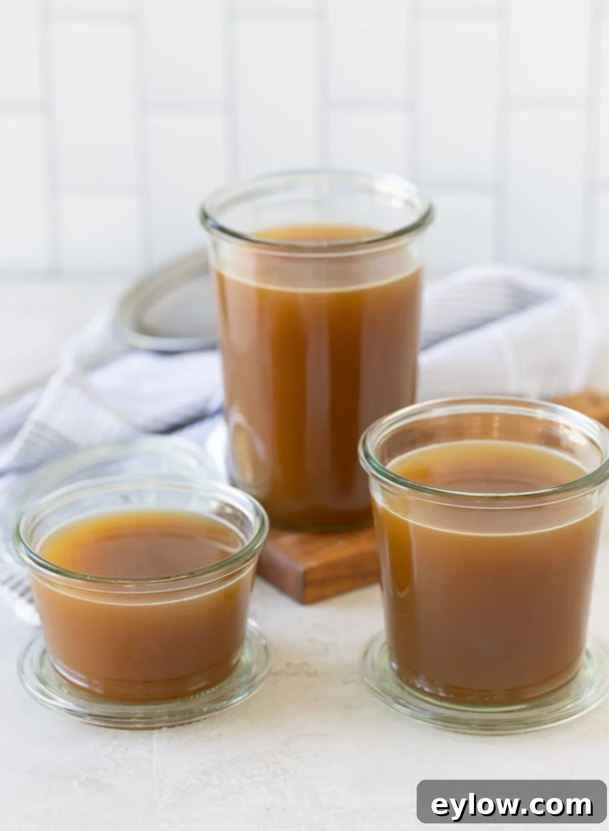 Homemade Turkey Stock 2 Finished golden brown turkey broth in glass jars.