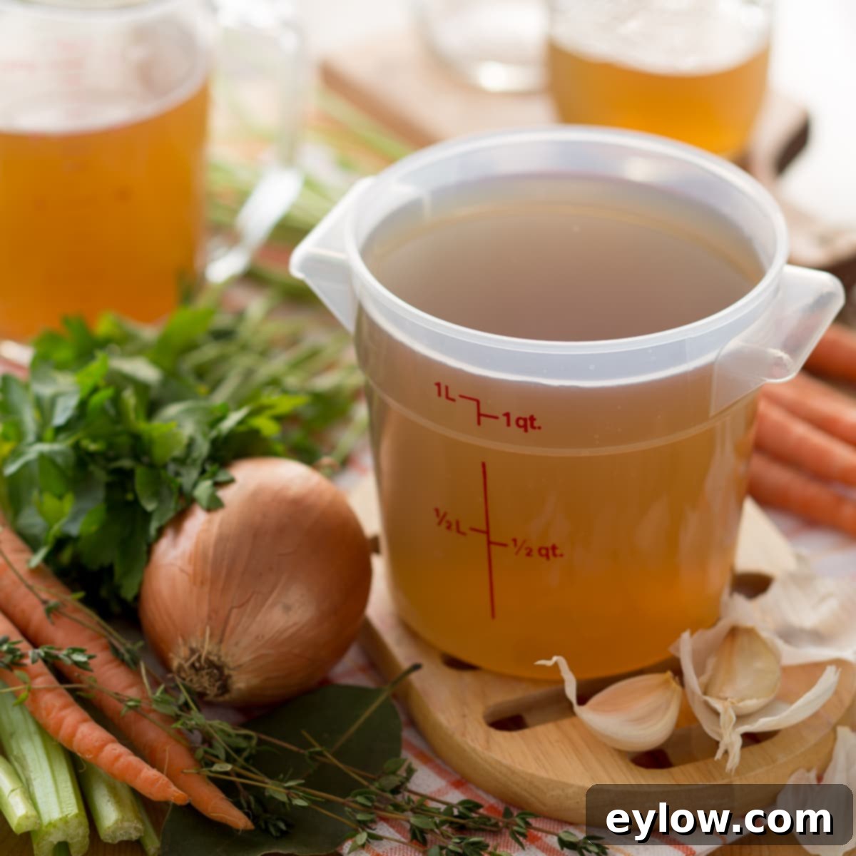Golden homemade broth in a quart container. 